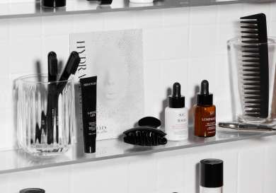Skincare products arranged on glass shelving.