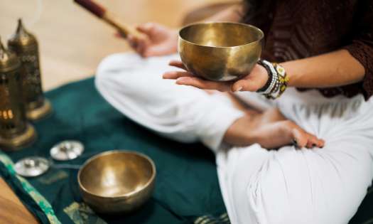 Person using metal singing bowl .