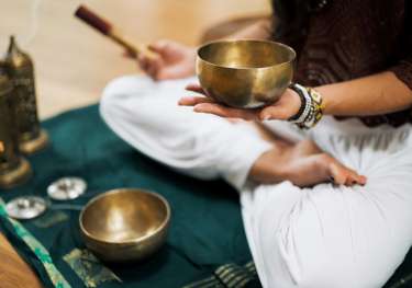 Person using metal singing bowl .