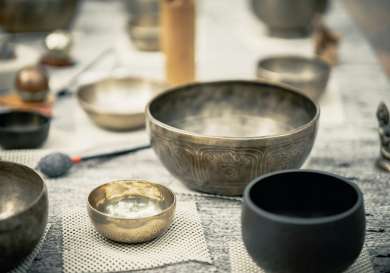 Set of singing bowls arranged on mat.