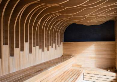 Photo inside sauna with curved ceiling details in wood .
