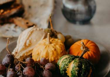 Bowl containing squash and grapes.