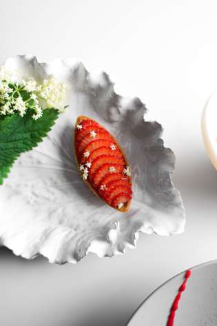 Strawberry dessert on leaf-shaped plate.