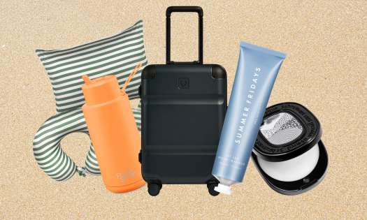 Travel-themed gift items arranged on white sand background.