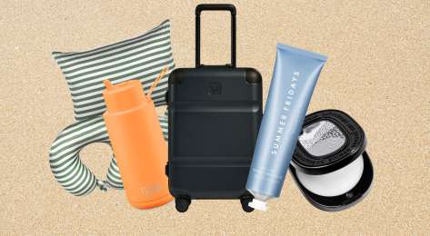 Travel-themed gift items arranged on white sand background.