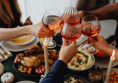 People clinking glasses over meal .