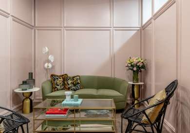 Green sofa and wicker chairs in clinic waiting area.