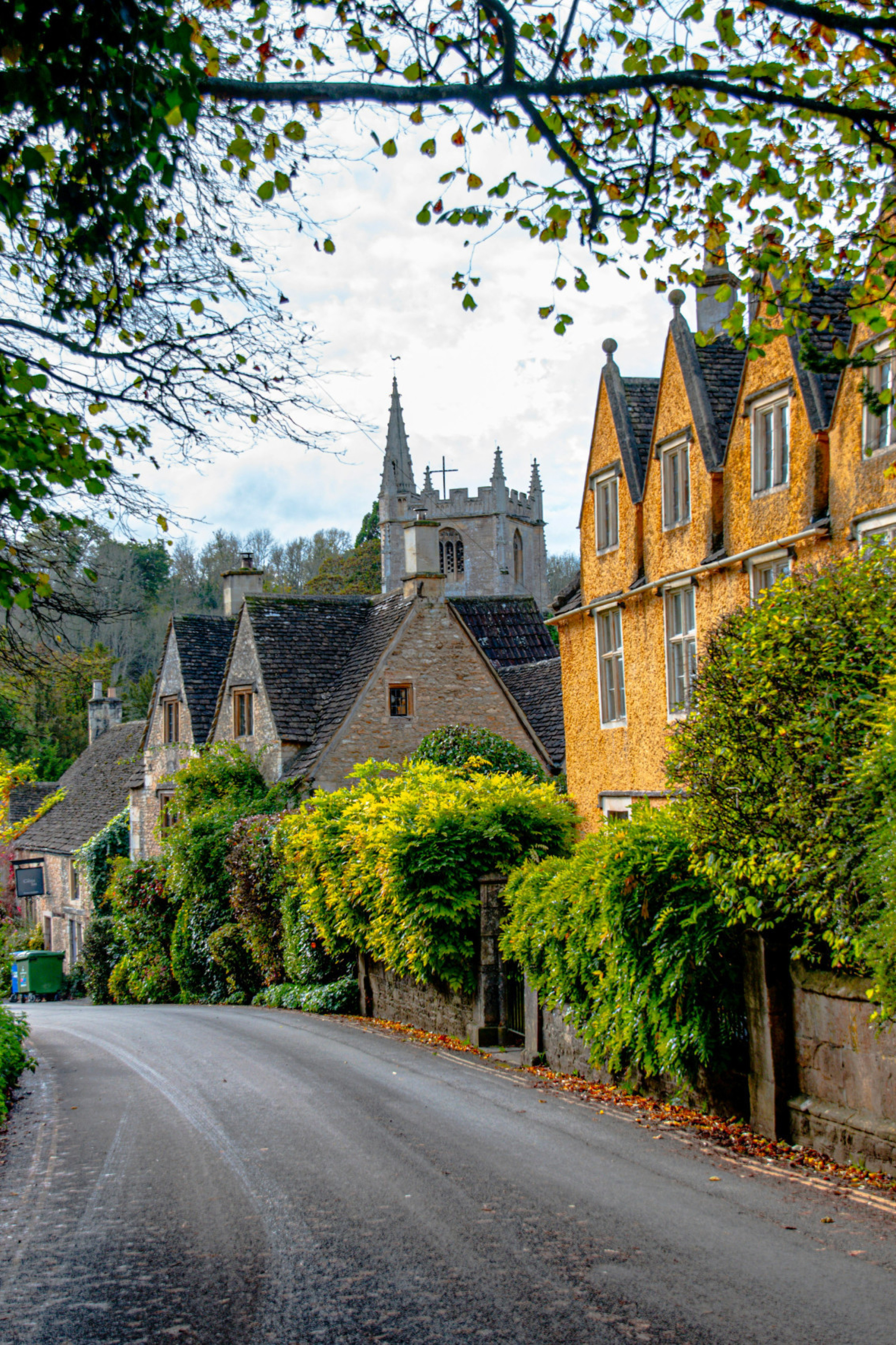 road in the cotswolds with yellow house 