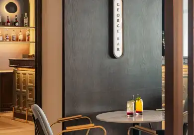 Table with two chairs inside the george penang hotel .