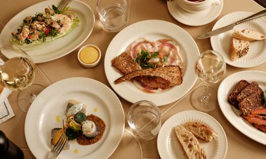 Lunch spread in restaurant with glasses of wine.
