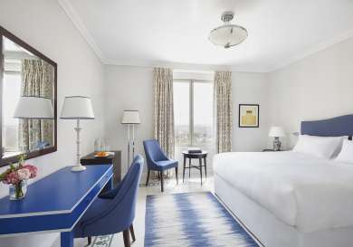 Classic hotel room with blue and white accents .