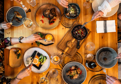 Aerial view of diners tucking into an array of dishes at a restaurant .