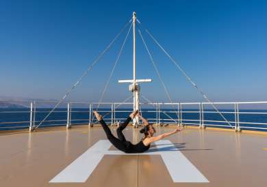 Person doing yoga onboard a yacht.
