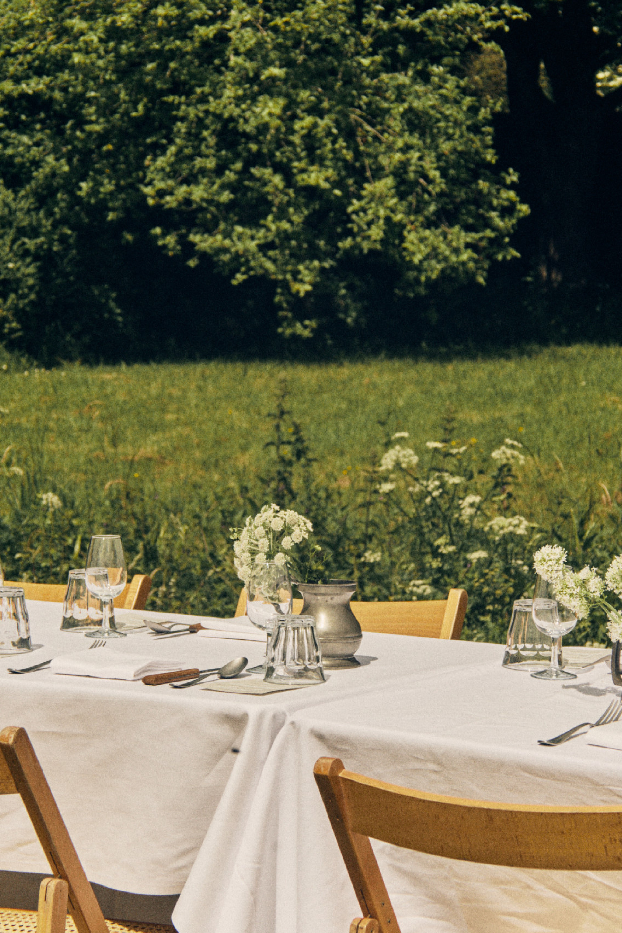outdoor tables with linen tablecloths and jars of flowers