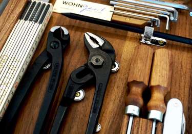 Tools are neatly arranged in a wooden case.