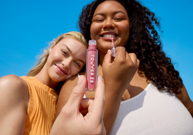 Two models posing with pink lip gloss.