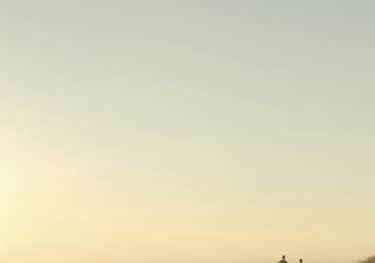 Two people running on hill.