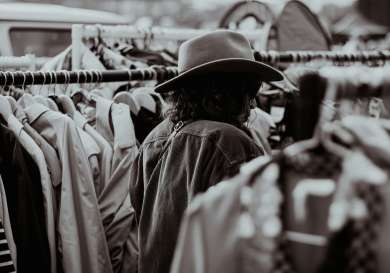 Woman browsing clothes at vintage market.