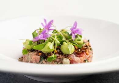 Fish dish topped with herbs .