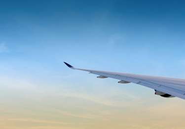 Plane wing with blue sky in the background.