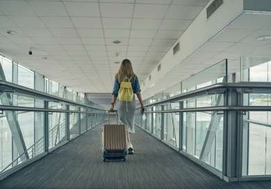 Women pulling suitcase through airport .