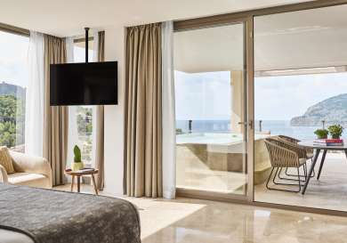 Hotel suite with balcony and outdoor pool.