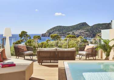 Hotel penthouse balcony area with seating and raised pool.
