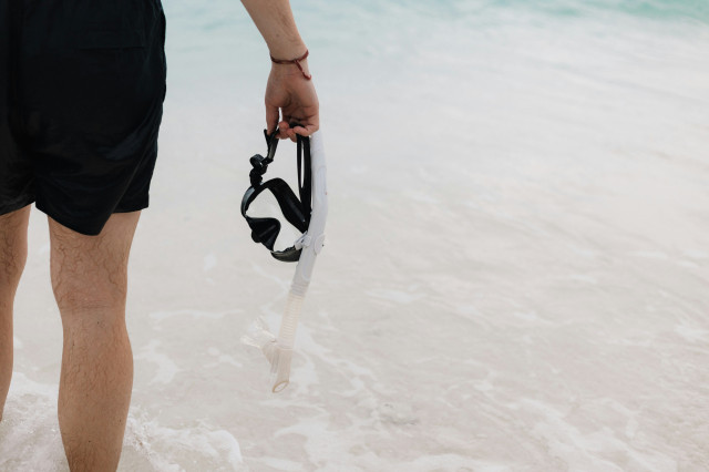 person holding snorkelling mask in the maldives