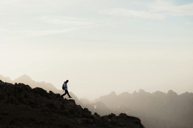 person hiking in hazy mountains