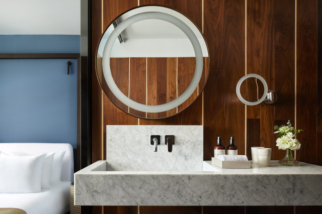 hotel bathroom with round mirror and marble