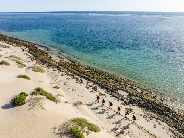 people walking along australian coast 