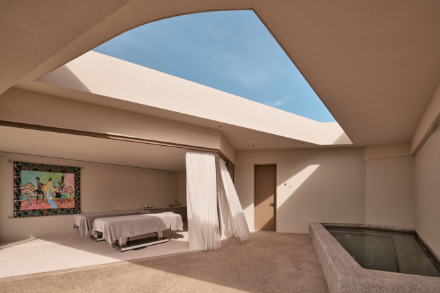 hotel spa treatment room with two beds and artwork