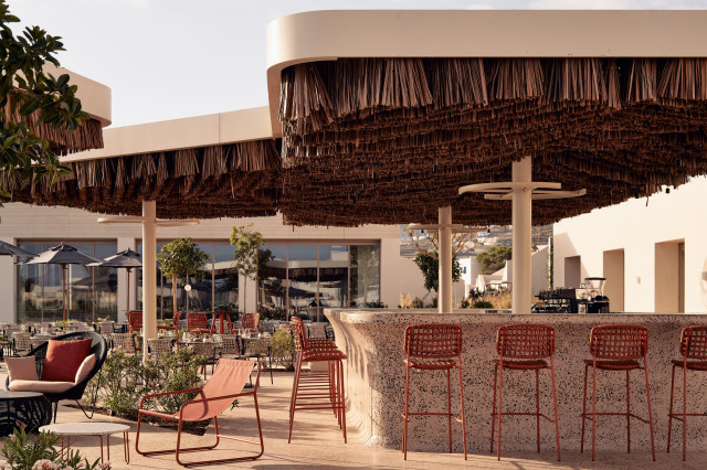 outdoor hotel restaurant with red chairs and raffia details