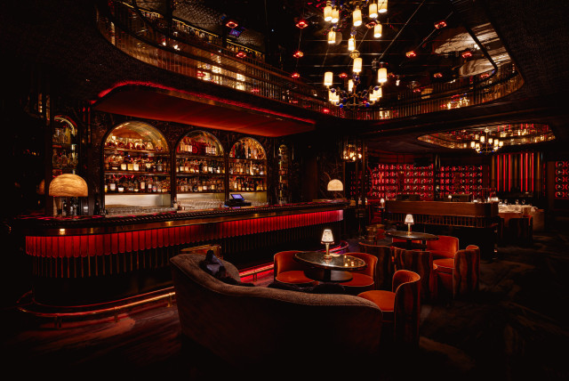bar with low lighting and red seats 