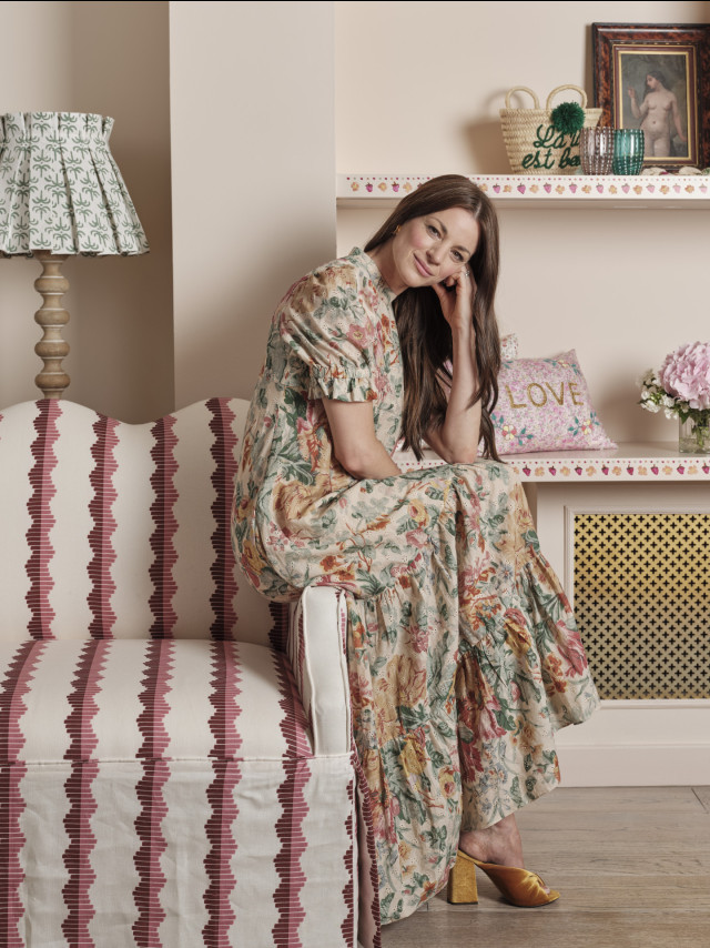 headshot of rebecca hughes posing on striped chair 