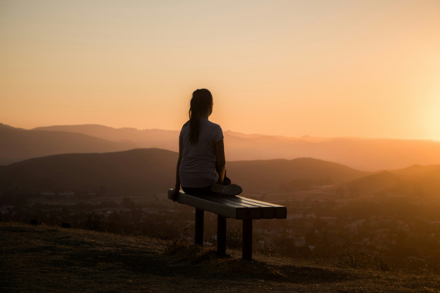 woman meditating on bench