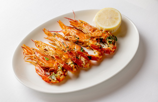 grilled prawns served with a lemon slice