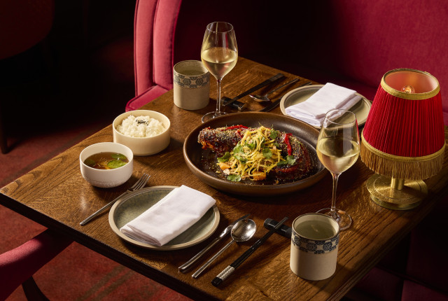 seabass dish on wooden table with two plates