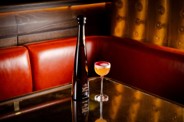 bottle of don julio on table with cocktail
