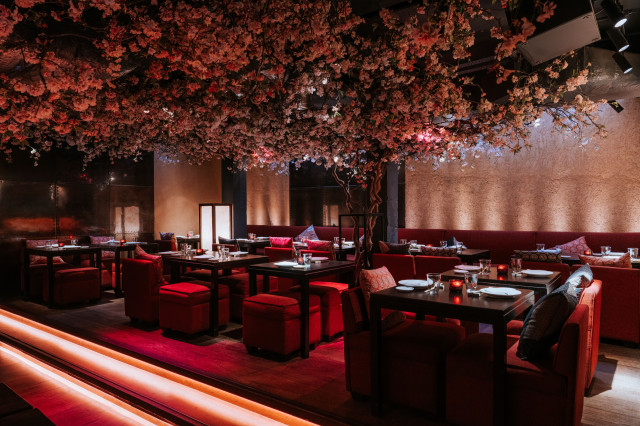 bar area with red seating and flower ceiling display