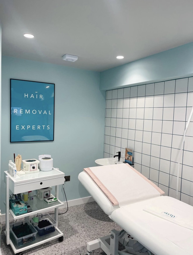 treatment room with foldable bed and white tiles