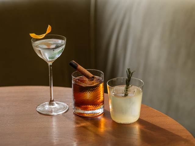 three cocktails on round wooden table
