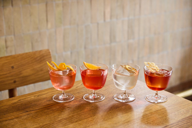 four negronis on wooden table at the italian greyhound