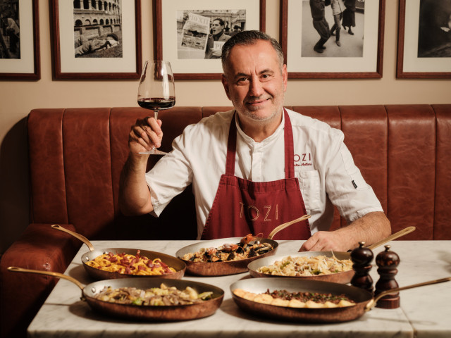 chef at tozi london with five different dishes and a glass of red wine