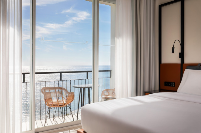 hotel bedroom with sea view and floor-to-ceiling windows