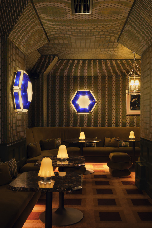 seating area inside Tramp with blue wall lights