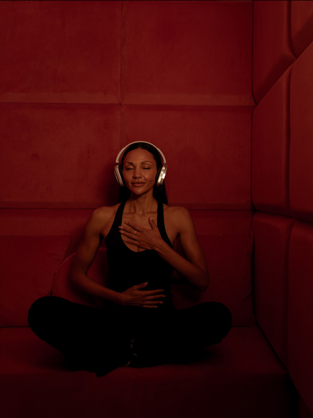woman wearing headphones in red calm room
