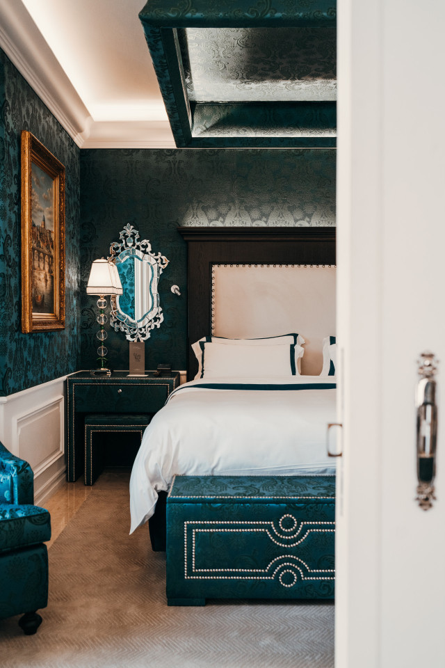 hotel room with teal walls and teal furniture