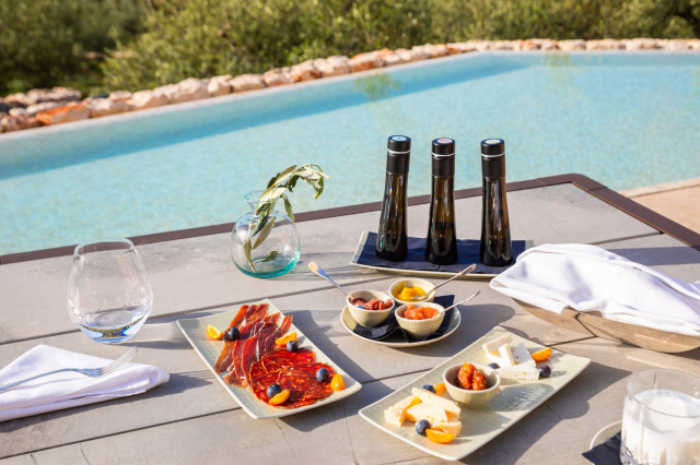 three plates of food served on table next to pool 