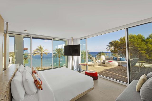 ibiza hotel bedroom with floor-to-ceiling windows looking out to the sea 